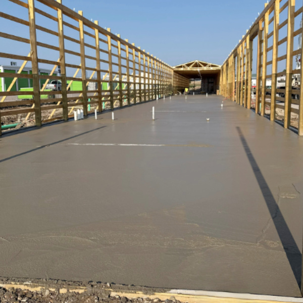 Freshly poured concrete floor inside a commercial building under construction.